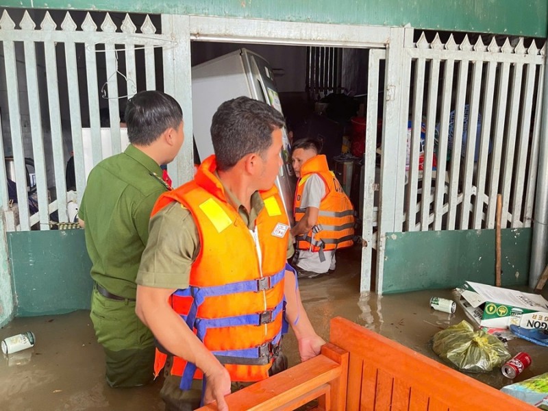 Luc luong cong an ho tro nguoi dan di doi tai san den noi an toan. Anh: Cong an cung cap