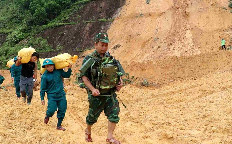 Soldiers crossed landslides and blocked roads in Tra My, Da Nang to provide food to people. Photo: Quang Hung