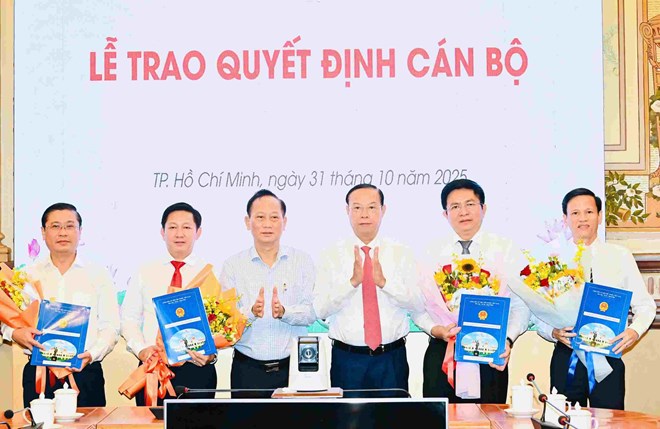 Lanh dao TPHCM trao quyet dinh cho Giam doc va pho Giam doc Trung tam Phat trien quy dat TPHCM. Anh: Viet Dung