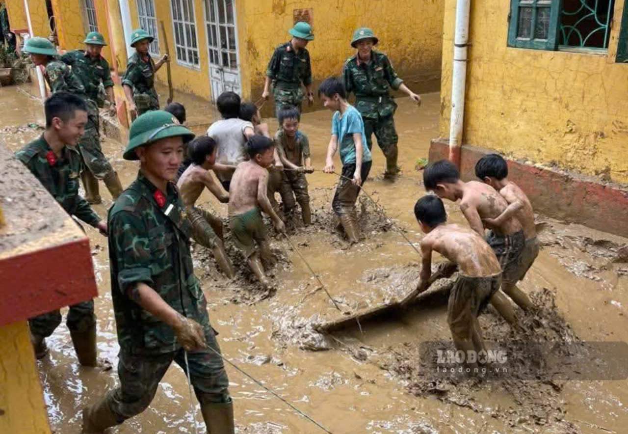 Students of Mo Vang Boarding School for Ethnic Minorities clean up mud with the authorities. Photo: Le Luong.