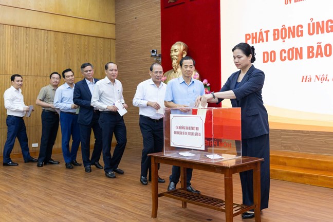 La Sra. Ha Thi Nga - Miembro del Comite Central del Partido Vicepresidenta del Comite Central del Frente de la Patria de Vietnam junto con los delegados unieron fuerzas para apoyar a los compatriotas de las provincias y ciudades para que superen los daños causados por la tormenta numero 10. Foto: Quang Vinh