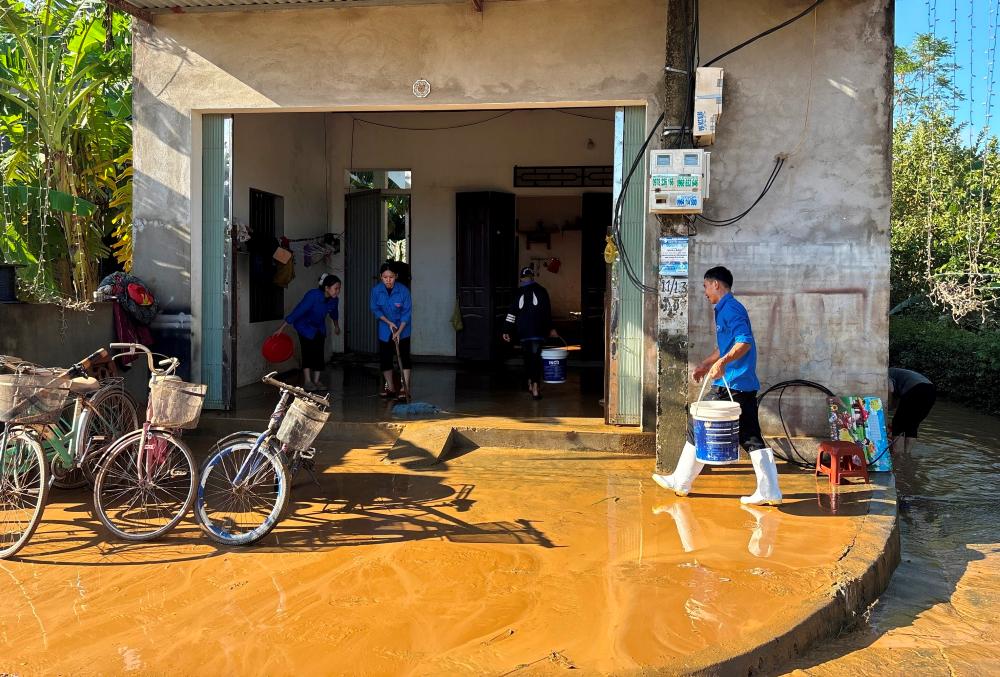 Luc luong thanh nien tinh nguyen giup nguoi dan o xa Kim Tan, tinh Thanh Hoa don dep nha cua sau ngap lut. Anh: Minh Hoang