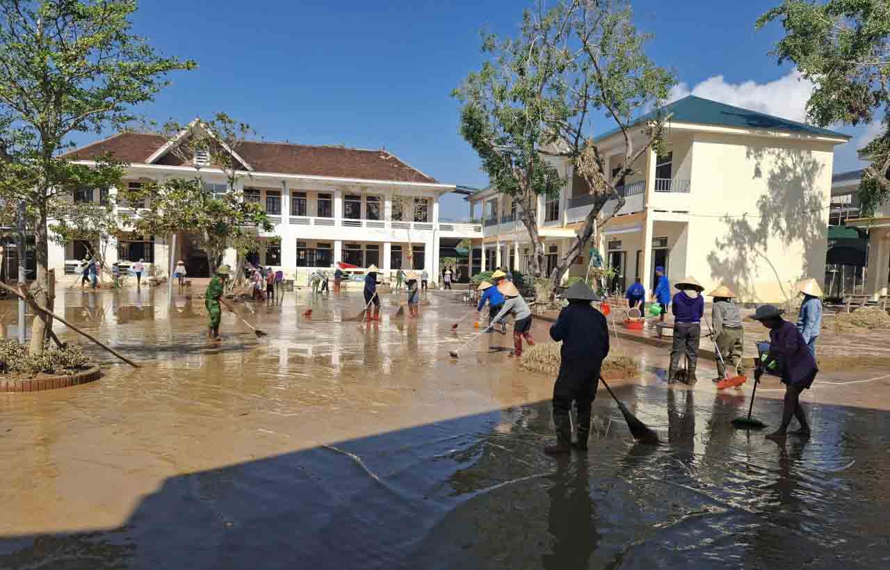On the morning of October 4, teachers and parents gathered to clear mud at Quang Vinh Primary School right after the floodwaters receded. Photo: Tran Tuan.