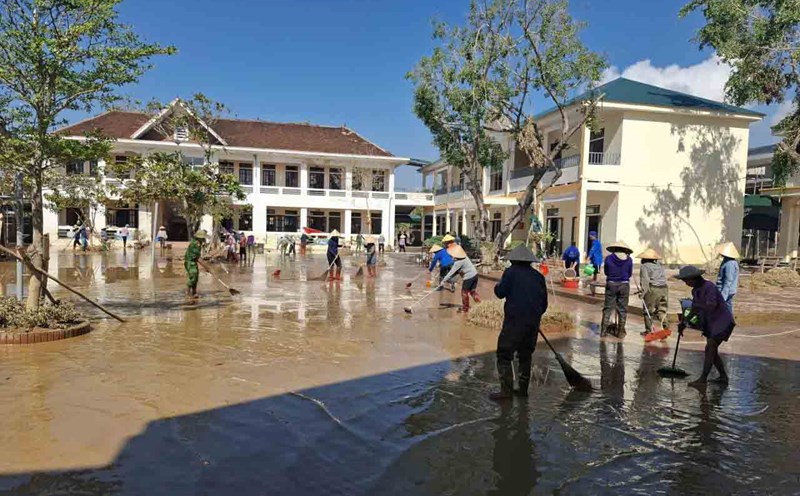 On the morning of October 4, teachers and parents gathered to clear mud at Quang Vinh Primary School right after the floodwaters receded. Photo: Tran Tuan.