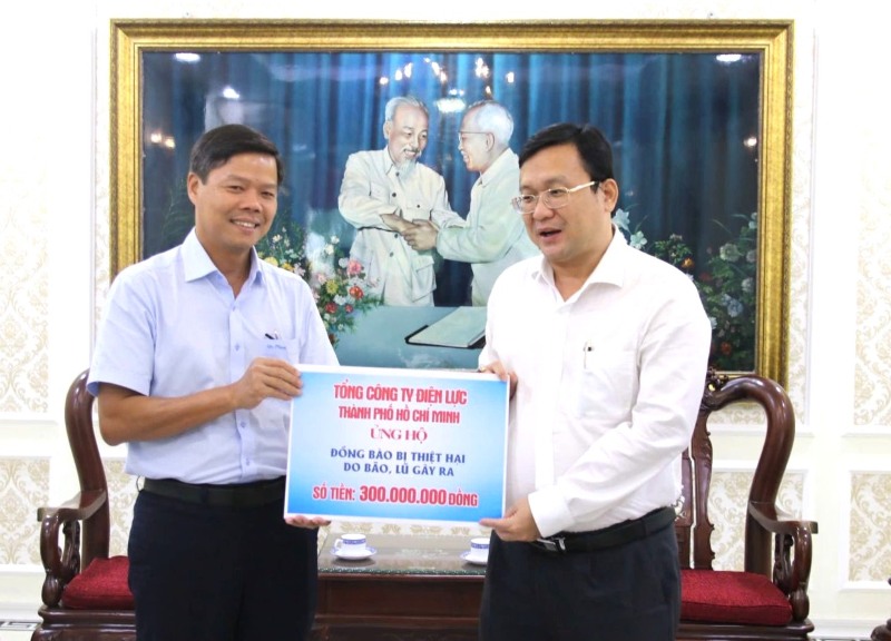 Mr. Le Van Minh - Chairman of EVNHCMC Trade Union (left) - representative of EVNHCMC workers' collective presented money to the Vietnam Fatherland Front Committee of Ho Chi Minh City to overcome the consequences of storm No. 10. Photo: Duc Long