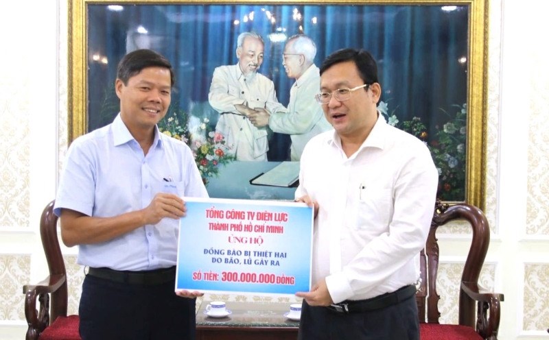 Mr. Le Van Minh - Chairman of EVNHCMC Trade Union (left) - representative of EVNHCMC workers' collective presented money to the Vietnam Fatherland Front Committee of Ho Chi Minh City to overcome the consequences of storm No. 10. Photo: Duc Long