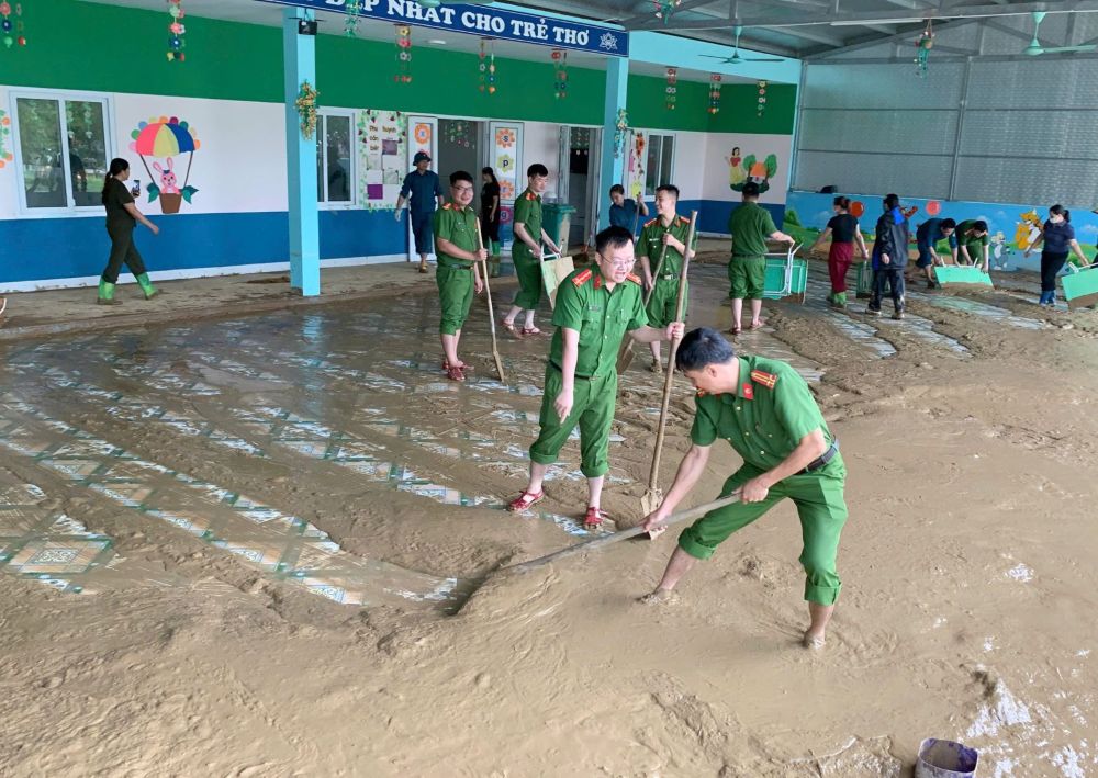 Luc luong cong an giup nha truong don bun dat sau mua lu o xa Xuan Chinh, tinh Thanh Hoa. Anh: Cong an Thanh Hoa