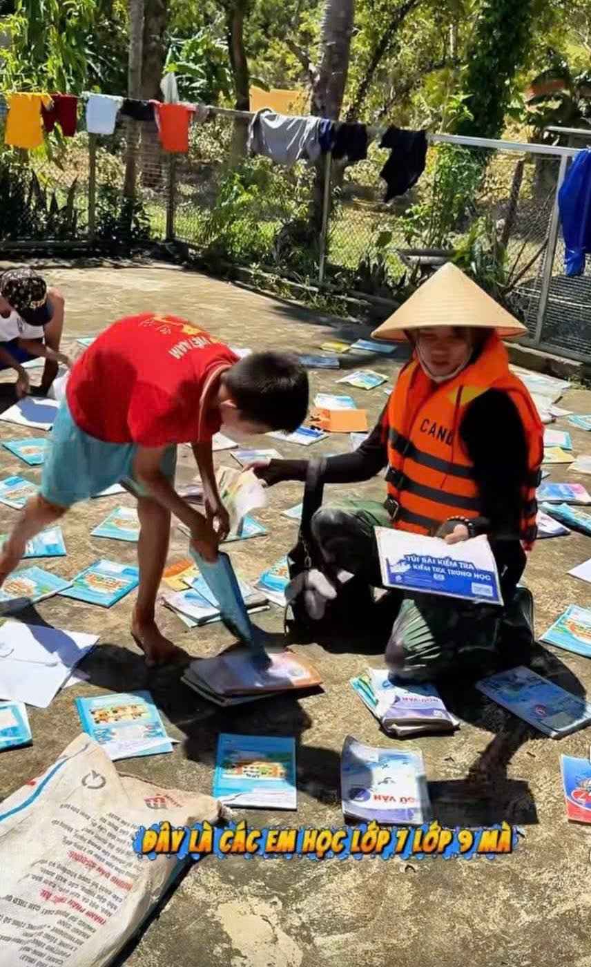 Can bo cong an ho tro hoc sinh lam sach va hong kho sach vo. Anh: Ngoc Anh