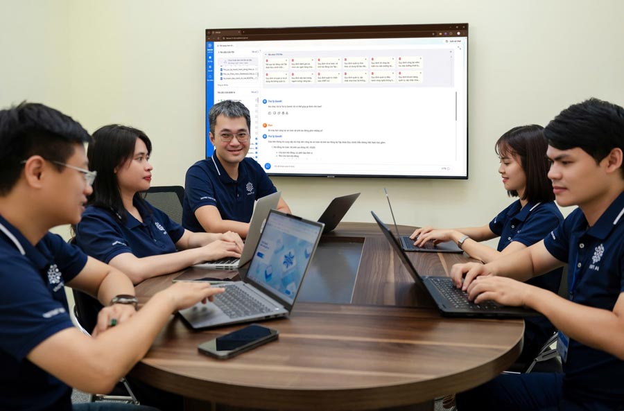 レ・タイ・フンさん(中央)は、仕事の過程で同僚と意見交換しています。写真:Ngo Linh