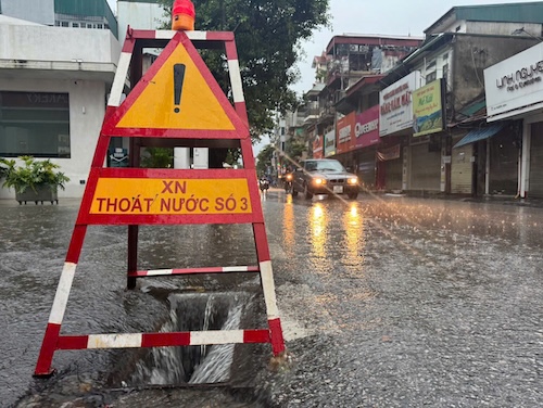 5h sang, ong Le Van Thiep – cong nhan Xi nghiep Thoat nuoc so 3 – da co mat tai pho Truong Dinh, Ha Noi de mo nap ho ga, dam bao he thong thoat nuoc thong suot, phuc vu an toan cho phuong tien luu thong. Anh: Hanh Thom 