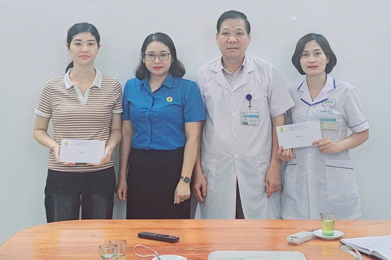 Ba Nguyen Thi Huong, Chu tich Cong doan xa Luc Yen tang qua cho cac doan vien co hoan canh kho khan tai Trung tam Y te khu vuc Luc Yen. Anh: Nguyen Thanh Son  