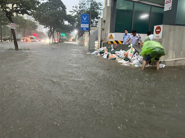 Nuoc ngap qua banh xe o to tai pho Pham Van Bach, cac chung cu gia co cua ham, trang nuoc tran vao. Anh: Thieu Trang