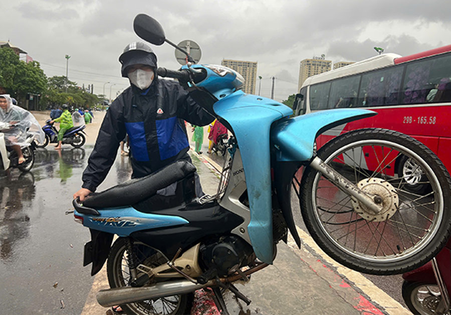 Nguoi dan doc nguoc xe may de nuoc chay ra ngoai. Anh: Cuong Ngo