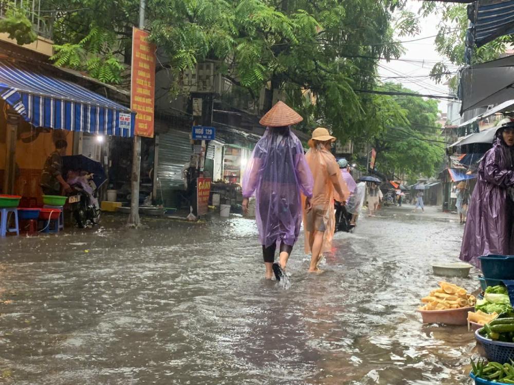 Con mua lon tu sang som 7.10 khien nhieu tuyen pho, con duong tai Ha Noi ngap sau, nguoi dan di lai kho khan. Anh: Cuong Phuong