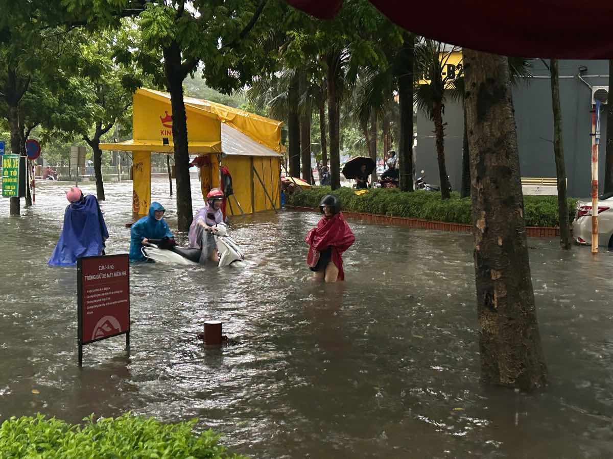 Xe ngap sau khien chi Binh phai nho nguoi dan gan do day xe vuot qua khu vuc ngap gan Khu do thi Dich Vong (phuong Cau Giay, TP Ha Noi). Anh: Huong Nha