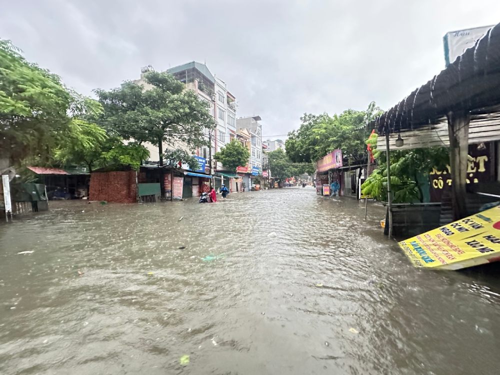 Nuoc ngap lut banh xe may noi anh Tung va ban thue tro. Anh: Quynh Chi