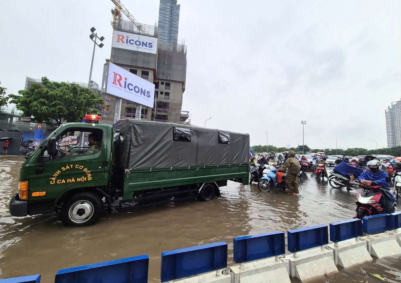 Mua lon bien nhieu tuyen pho Ha Noi thanh song, luc luong co dong co mat ho tro nguoi dan. Anh: Phan Anh