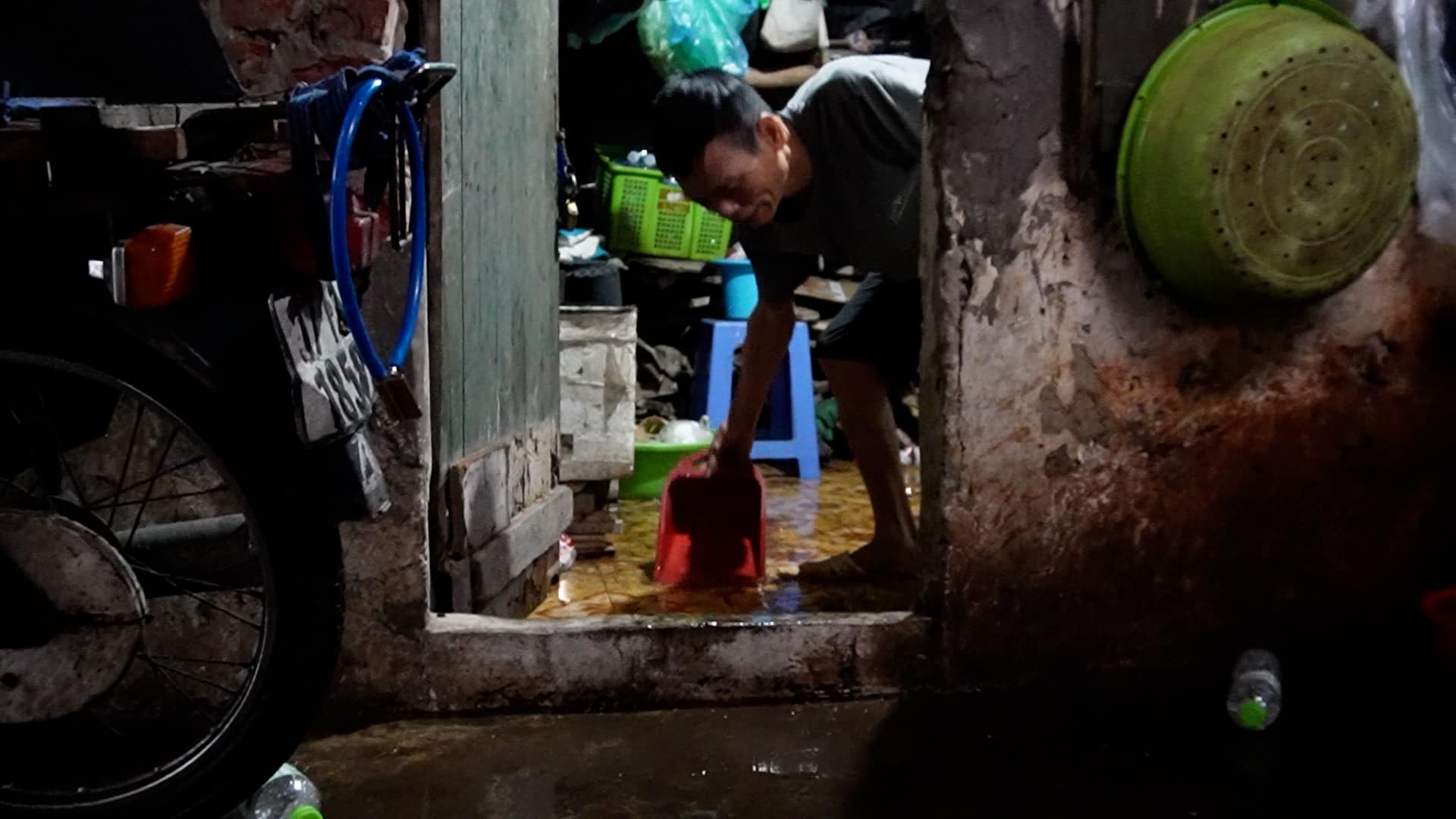 Workers struggle in the boarding house,patting each pot of water from early morning to prevent flooding