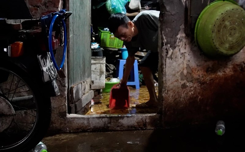 Workers struggle in the boarding house,patting each pot of water from early morning to prevent flooding