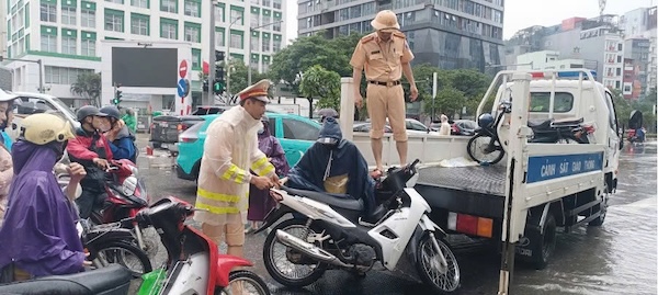 CSGT su dung xe chuyen dung dua nguoi dan qua diem ngap, bao dam an toan. Anh: Nguyen Tien