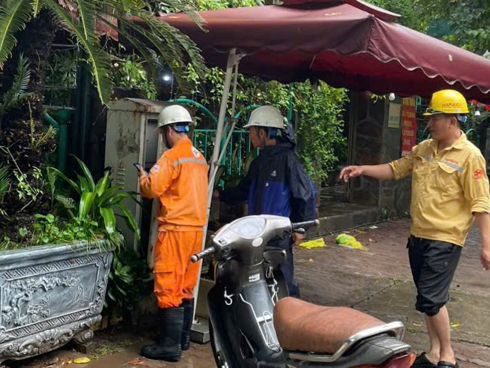 Traffic police quickly coordinated with electricity to fix the power leak. Photo: Tien Ngo - To The