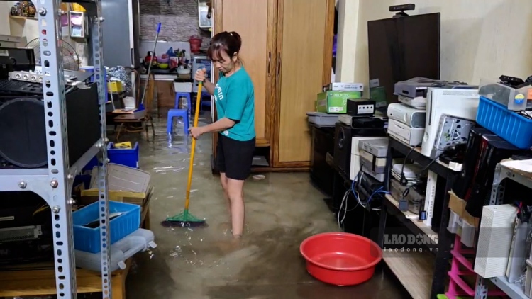 Chi Nguyen Thi Chien (phuong Cau Giay, Ha Noi) cho biet, sang nay mua lon keo dai khien nuoc tran vao nha, ngap den mep ban uong nuoc. Gia dinh chi lam nghe sua chua do dien tu nen nhieu thiet bi bi hu hong nang, gay thiet hai lon ve tai san. Anh: Linh Trang