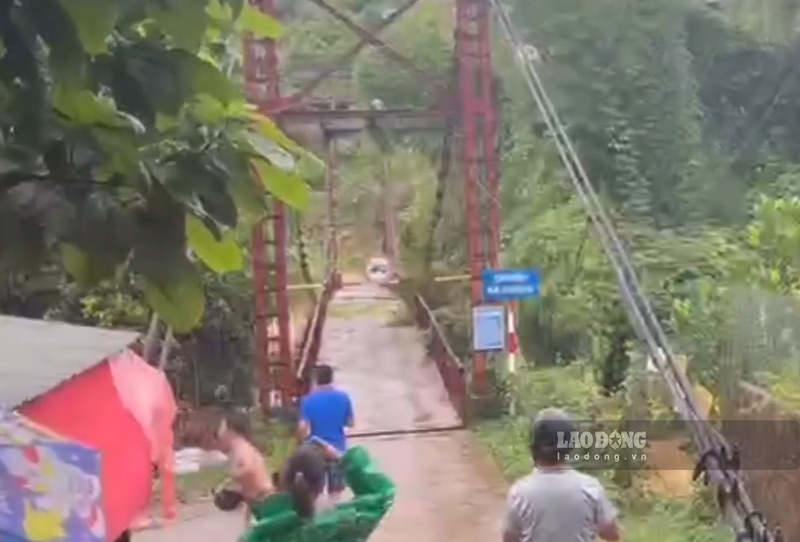 El agua de la inundacion y los arboles que fluyen en la corriente han destruido el puente colgante Na Hoang. Foto: Tan Van