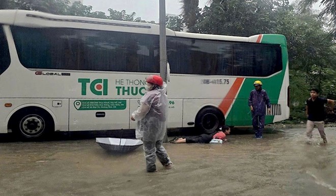 Nguoi phu nu nga sap gan cot den chieu sang, nghi do dien giat. Anh: CACC