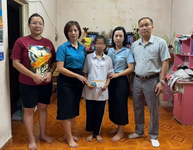 Entrega de dinero de apoyo a la niña Nguyen Thi Thanh Thao (camisa blanca). Foto: Le Van Thuan