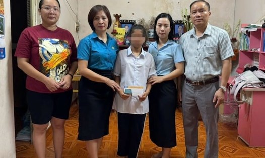 Công ty Môi trường trao tiền hỗ trợ cháu Nguyễn Thị Thanh Thảo (áo trắng). Ảnh: Lê Văn Thuấn