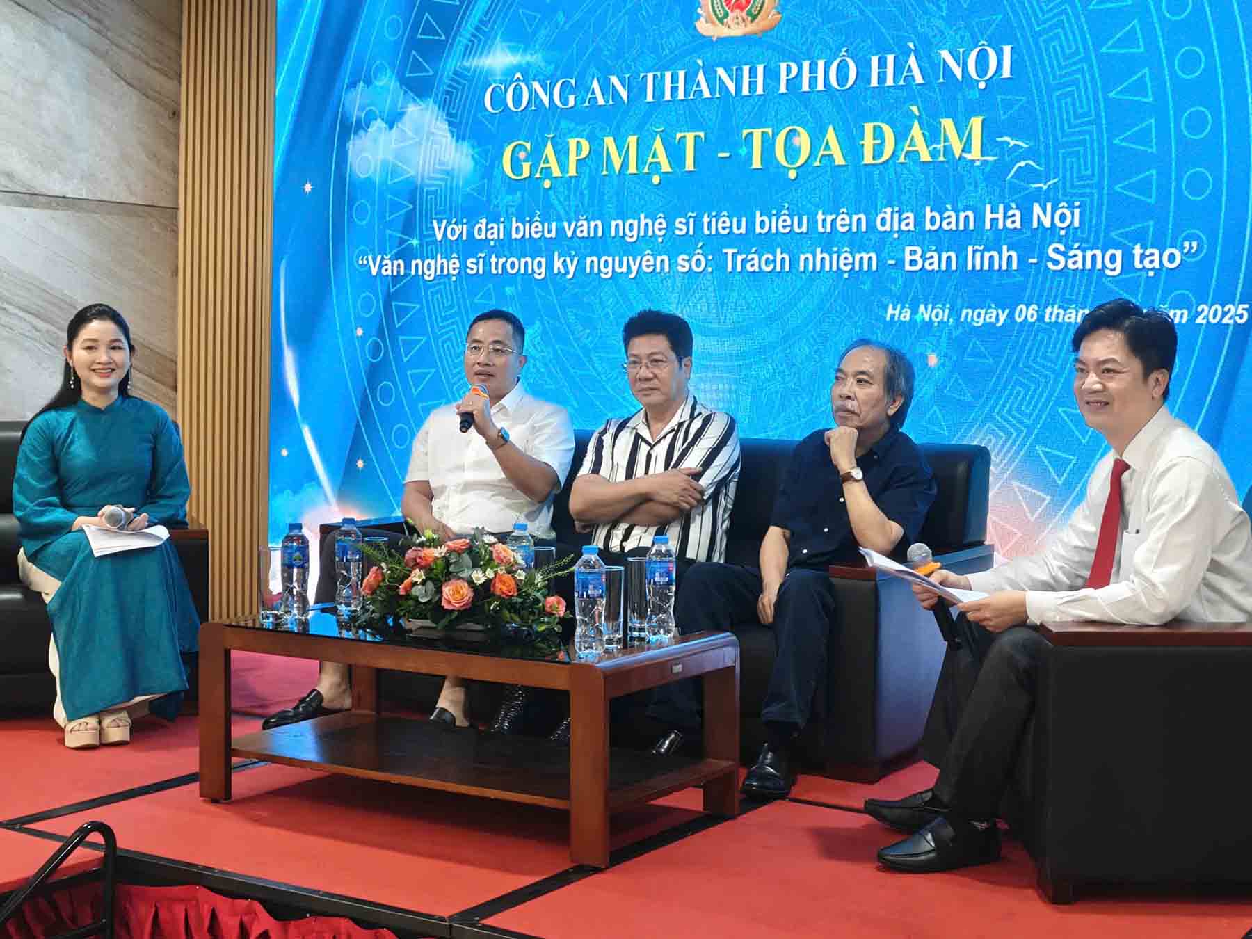 Le directeur adjoint de la police de Hanoï Nguyen Thanh Long discute et echange avec des artistes. Photo : Police de Hanoï