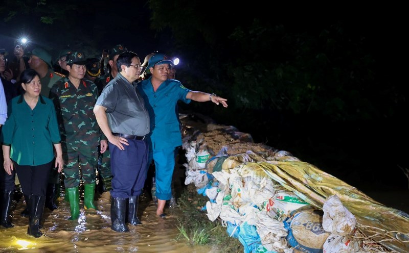 El Primer Ministro Pham Minh Chinh inspecciona el trabajo de respuesta a las inundaciones en las comunas de Trung Gia Da Phuc la ciudad de Hanoi lugares que estan profundamente inundados debido al aumento del nivel del agua de las inundaciones en los rios. Foto: VGP/Nhat Bac