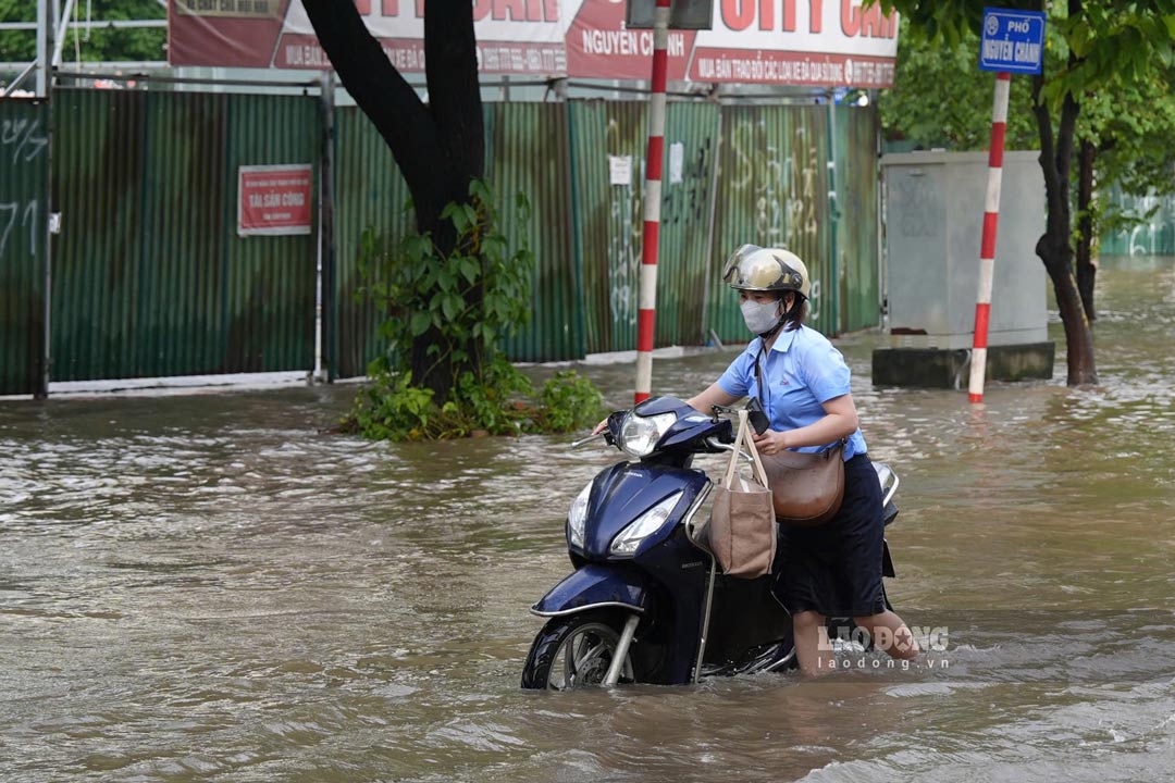 Nuoc ngap qua nua banh xe may tren duong Nguyen Chanh, khien nguoi dan di chuyen kho khan, nhieu xe chet may phai dat bo qua doan ngap. Anh: Duc Thien - Thieu Trang