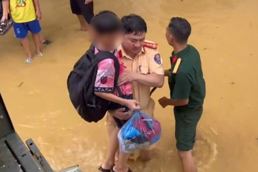 By 12:00 on October 8, the Hanoi Traffic Police force had supported the evacuation of 15 households in the downstream area of the Cau River to safety. Photo: Tien Ngo