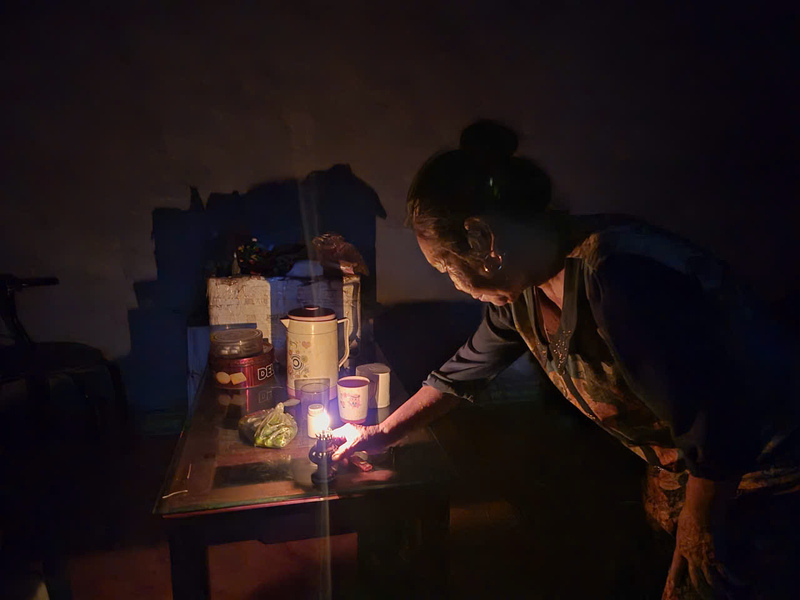 In the middle of the flood, people lit oil lamps to eat rice. Photo: Khanh Linh