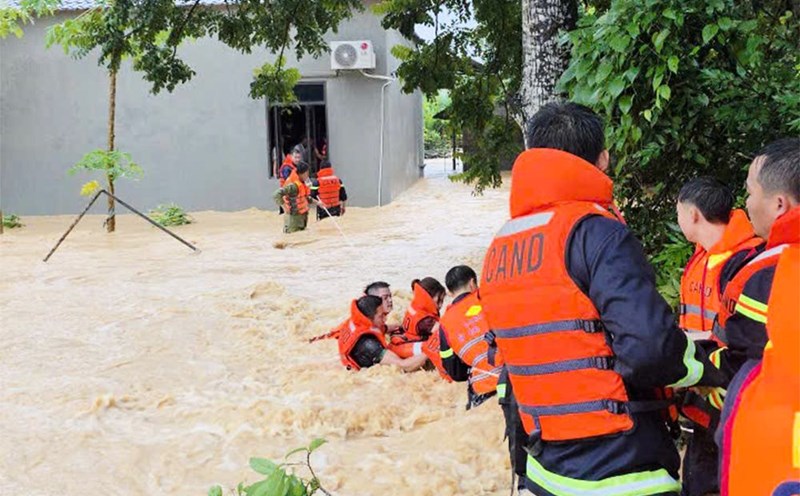 Officers and soldiers of Bac Ninh Provincial Police net a rope to bring a family of 5 people trapped in a house surrounded by floodwaters in Dong Ky commune, Bac Ninh province, in the early morning of October 7. Photo: Provided by the people