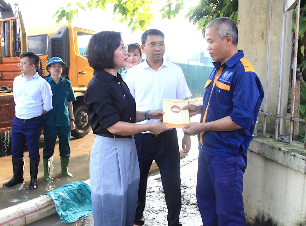 Ba Bui Huyen Mai trao qua, dong vien nguoi lao dong khac phuc tinh trang ngap lut tai phuong Tu Liem. Anh: MTTQ Viet Nam TP Ha Noi