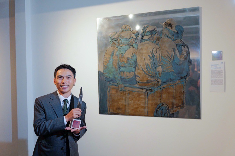 Painter Cao Van Thuc with his work. Photo: Organizing Committee.