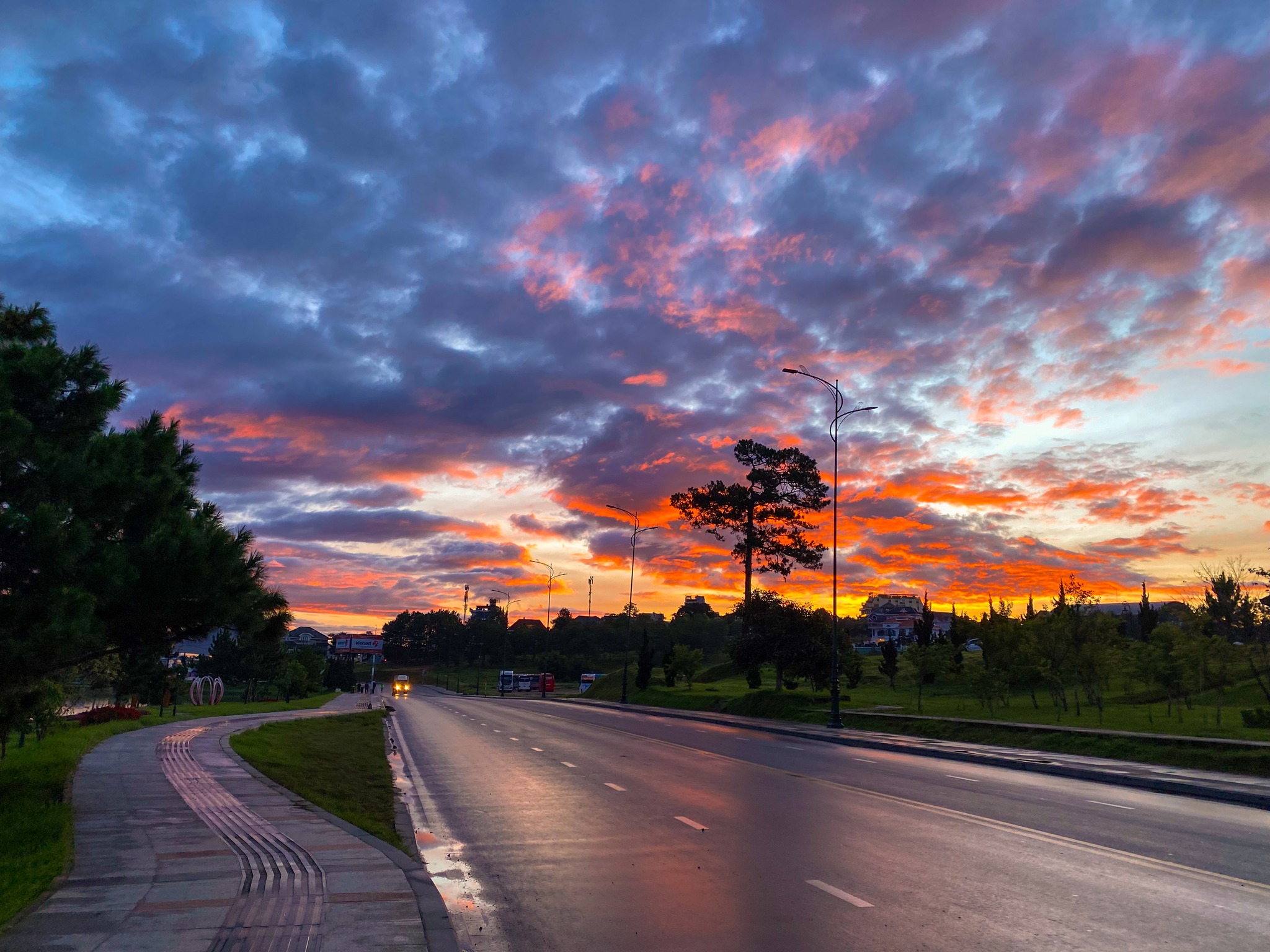 Herr Dungs vertraute und bevorzugte Route ist die Route um den Xuan-Huong-See mitten im Zentrum der Bergstadt Da Lat. Dieses Foto zeigt die Morgendämmerung zwischen 5 und 6 Uhr morgens. Himmel und Wolken wechseln spektakulär ihre Farbe in leuchtenden Farben von Orange, Gelb, Rot, Rosa und Lila …