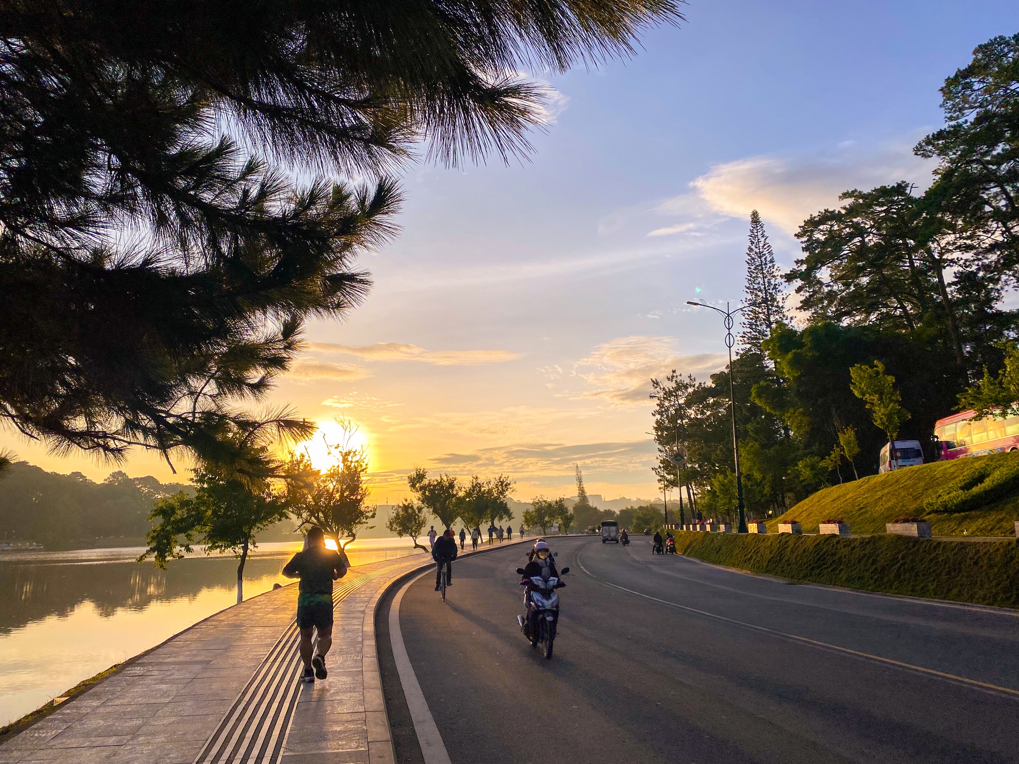 Der frühe Morgen in Dalat hat seinen ganz eigenen Charme: sanft, poetisch und ein wenig nostalgisch, wie ihn kein anderer Ort hat. Im Herbst, wenn der Regen aufhört, liegt der Morgennebel noch über den Kiefern, der See ist still und spiegelt die wechselnden Wolken und den Himmel wider. Menschen, die Dalat lieben, lieben die ruhige, friedliche Atmosphäre dieses Ortes, auch wenn sie schon viele Jahre hier leben. Das Geräusch der Autos auf der Straße ist ruhig, und auch die Schritte der Menschen sind in der Kälte sanft.