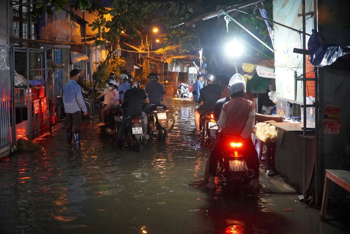 Nuoc dang cao, che lap mat duong ket hop troi toi khien viec di chuyen cua nguoi dan them phan kho khan. Anh: Chan Phuc