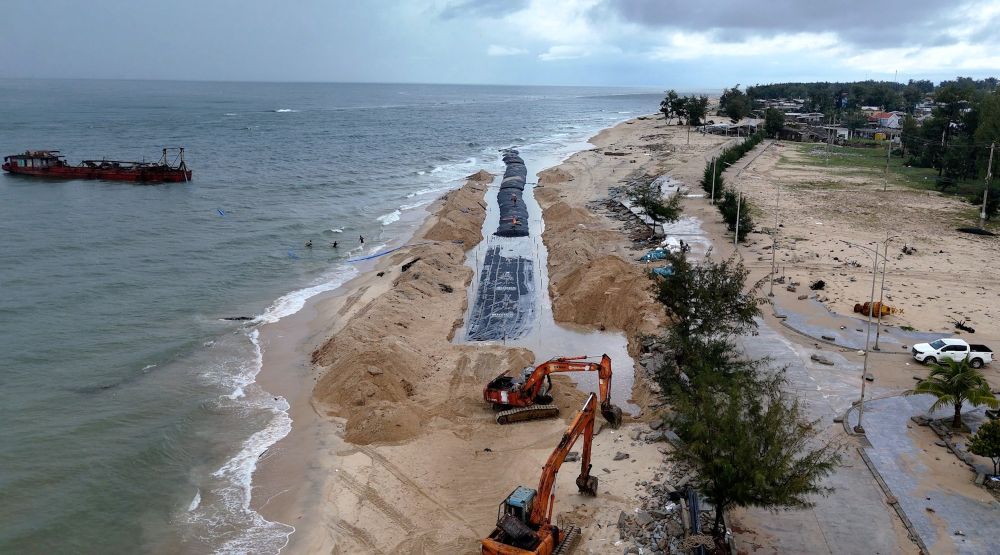 Mobilizing machinery and workers to urgently construct the soft embankment to prevent landslides on the Thuan An coast. Photo: Nguyen Luan