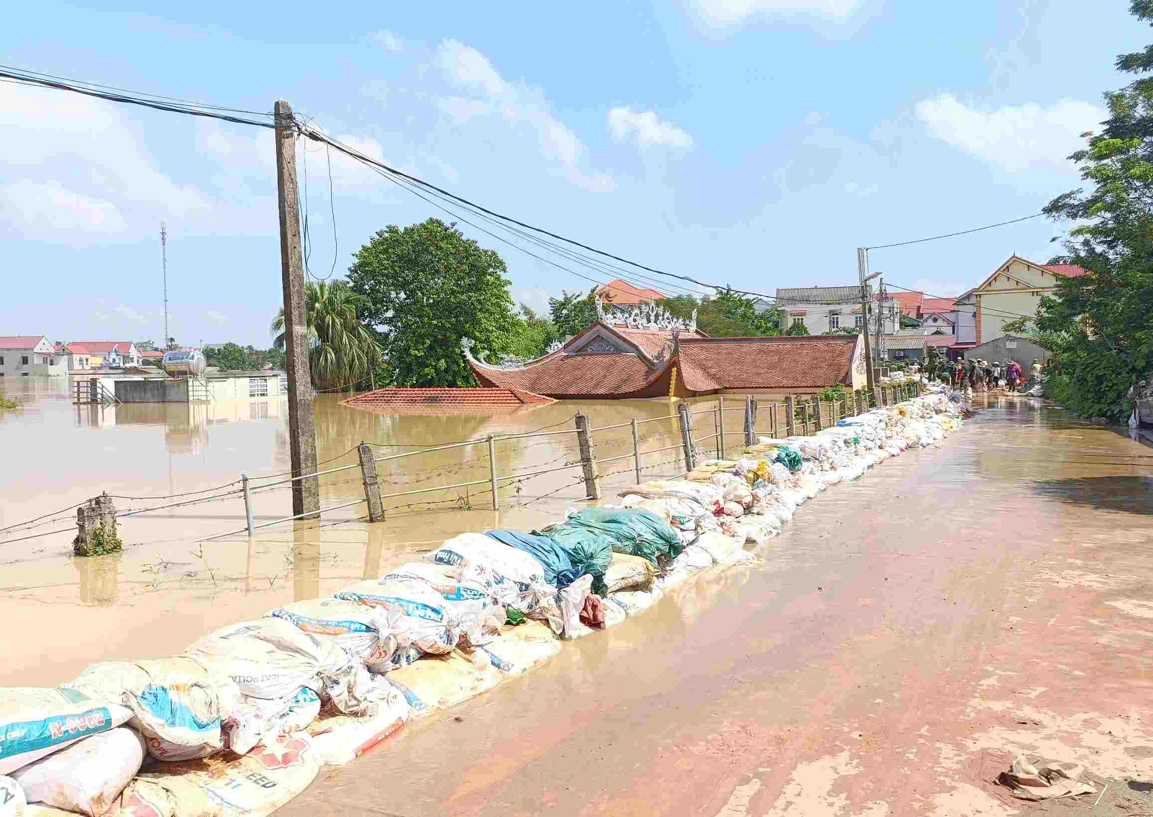 10月9日正午、バクニン省ホップティンコミューンで洪水を防ぐために土嚢を構築した人々と機能部隊。写真: Van Quang