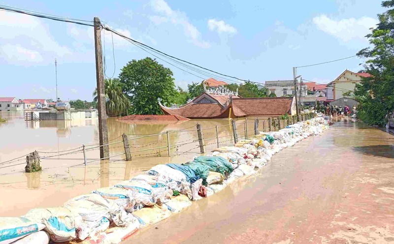 People and authorities build sandbags to prevent floodwaters in Hop Thinh commune, Bac Ninh, at noon on October 9. Photo: Van Quang