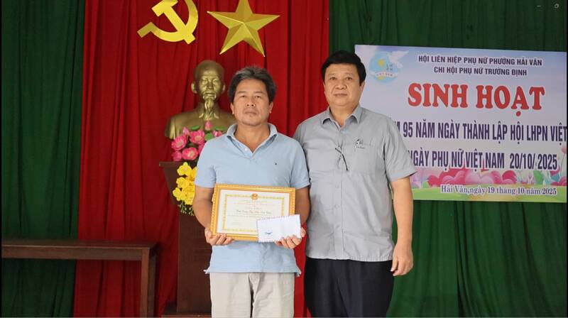 Chairman of Hai Van Ward People's Committee (Da Nang) Nguyen Thuc Dung praised and rewarded Mr. Tran Dinh Chien for his brave action in saving people in floods. Photo: Da Nang City People's Committee