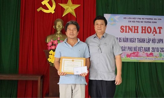 Chủ tịch UBND phường Hải Vân (Đà Nẵng) Nguyễn Thúc Dũng biểu dương, khen thưởng cho anh Trần Đình Chiến đã hành động quả cảm cứu người trong mưa lũ. Ảnh: UBND TP Đà Nẵng