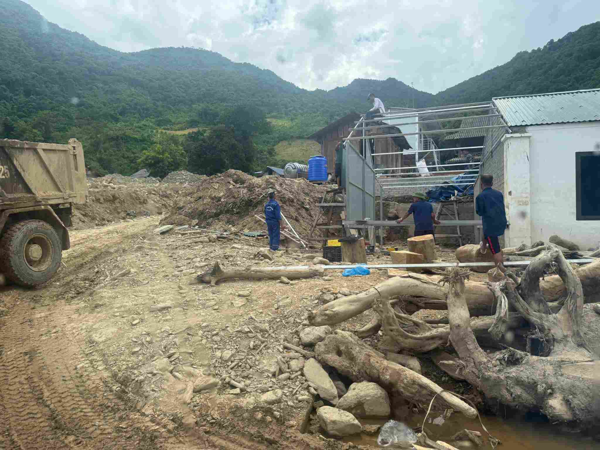 Nguoi dan dung lai nha cua sau khi bi lu cuon troi. Anh: QUANG DAI