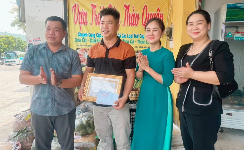 La Sra. Nguyen Thi Kim Loan Vicepresidenta del Comite Popular de la Zona Especial de Phu Quoc (camisa larga) elogio y entrego certificados de merito al Sr. Tran Hoang Phuong. Foto: Nam Phuong