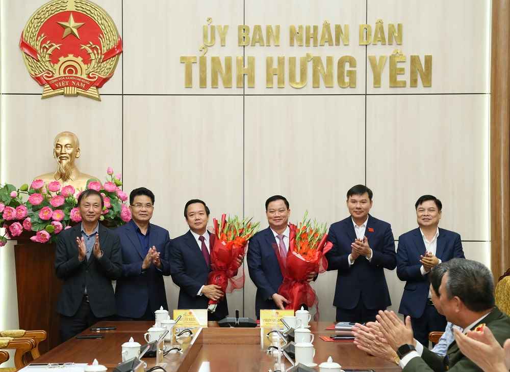 Cac lanh dao UBND tinh tang hoa chuc mung ong Nguyen Khac Than va ong Pham Quang Ngoc tai hoi nghi ban giao nhiem vu. Anh: Cong TTDT tinh Hung Yen