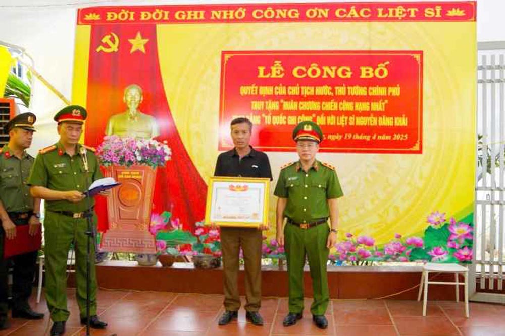 Trung tuong Nguyen Van Long - Thu truong Bo Cong an trao Huan chuong chien cong hang Nhat va bang To quoc ghi cong cho than nhan liet si Nguyen Dang Khai. Anh: Cong an tinh Hung Yen